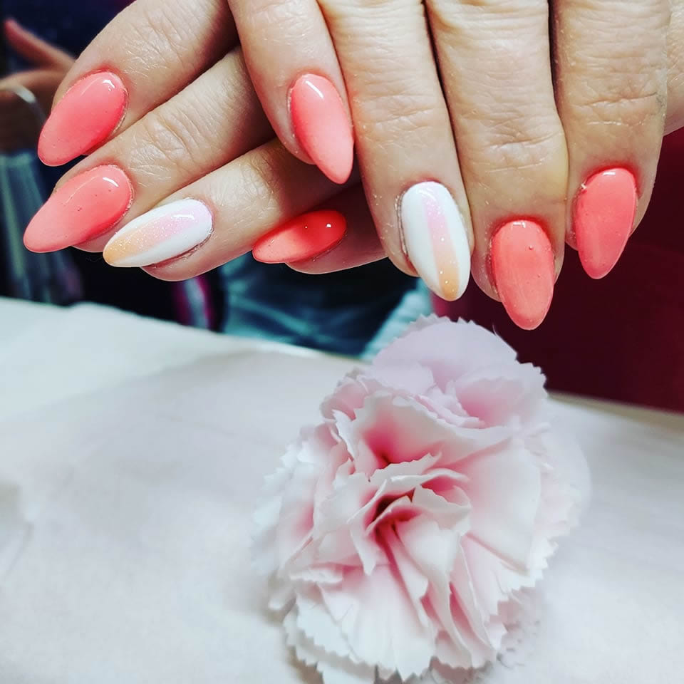 image of customer hands showing peach and white nails with a pink rose in the image display